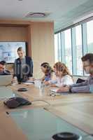 Young businesswoman with team working at conference table