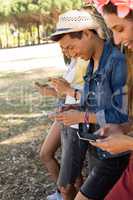 Smiling fiends using mobile phone while standing by camper van