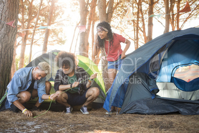 Young friends setting up tent at forest