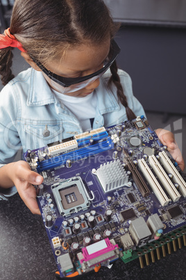 High angle view of concentrated elementary student examining circuit board
