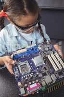 High angle view of concentrated elementary student examining circuit board