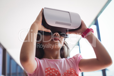 Low angle view of girl using virtual reality glasses against ceiling