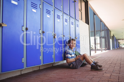 Portrait of smiling boy sitting by lockers