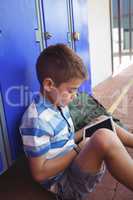 High angle view of boy using digital tablet by locker
