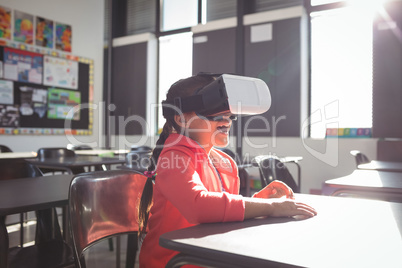 Girl using virtual reality glasses in classroom