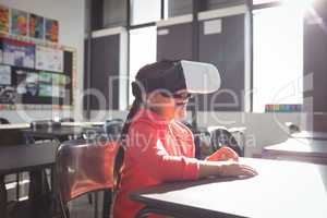 Girl using virtual reality glasses in classroom