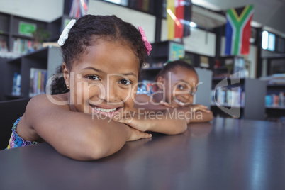 Portrait of smiling girls leaning on desk