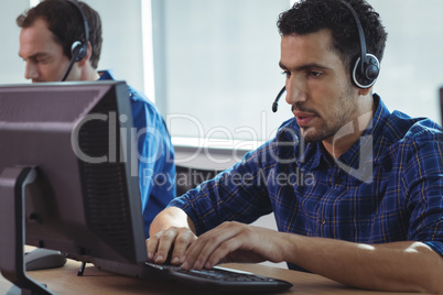 Focused businessman working on computer at call center