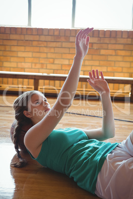 Female basketball player gesturing while relaxing on floor