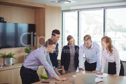 Business colleagues discussing around desk during meeting