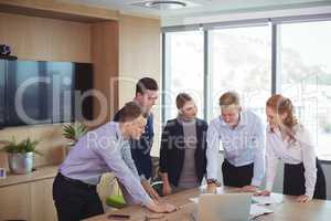 Business colleagues discussing around desk during meeting