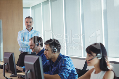 Portrait of supervisor with business team working at call center