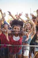 Cheerful young woman by railing enjoying at music festival