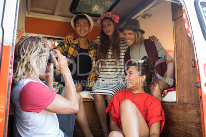 Man photographing friends sitting in camper van