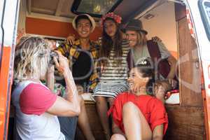 Man photographing friends sitting in camper van