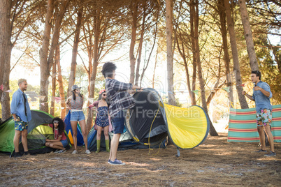 Young friends setting up their tents at countryside