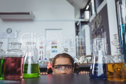 Portrait of elementary student hiding in laboratory