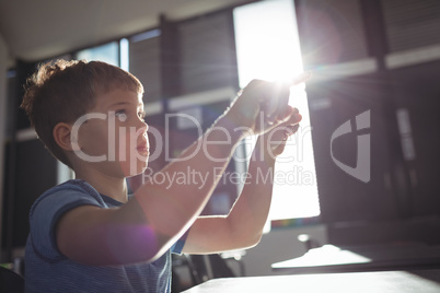 Boy gesturing while sitting at desk