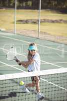 Girl playing tennis on court