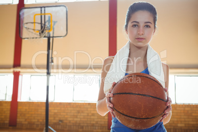 Portrait of female basketball player holding ball