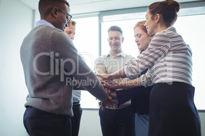 Business colleagues stacking hands at office