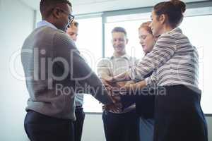 Business colleagues stacking hands at office