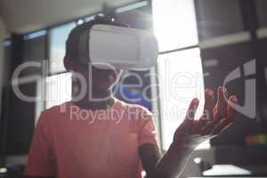 Boy wearing virtual reality simulator against windows