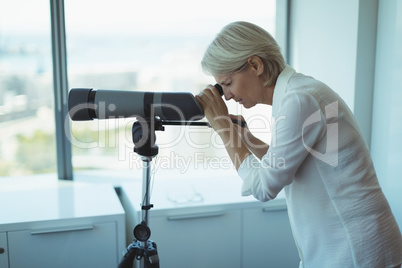 Side view of businesswoman using telescope