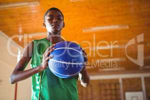Low angle portrait teenager holding ball