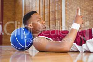 Side view of male basketball player using mobile phone