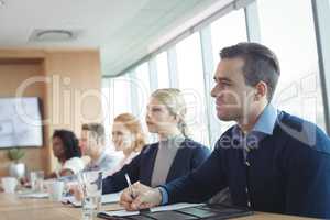 Concentrated business people sitting at conference table during meeting