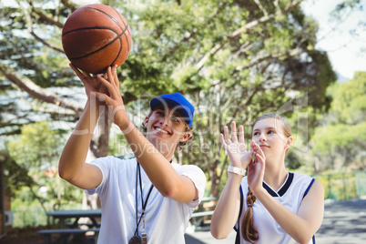 Coach training basketball player in court