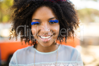 Close up portrait of smiling woman wearing artificial eyelashes