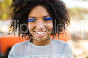 Close up portrait of smiling woman wearing artificial eyelashes