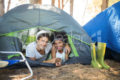 Portrait of couple with arm around relaxing in tent