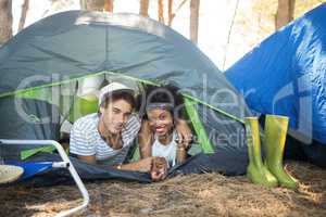 Portrait of couple with arm around relaxing in tent