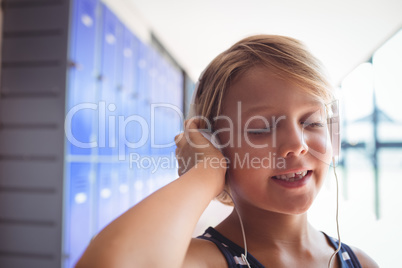 Elementary student with eyes closed listening music through headphones