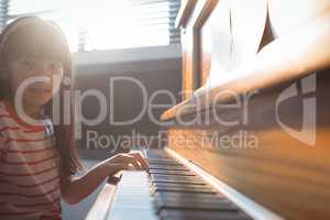 Portrait of girl practicing piano in class