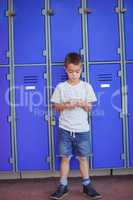 Full length of boy using mobile phone against lockers