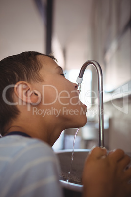 Close up of boy drinking water from faucet