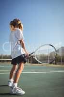 Girl holding tennis racket on court