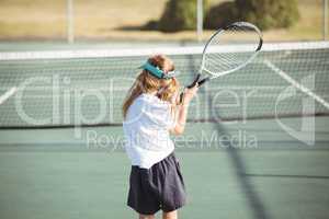 Rear view of girl playing tennis