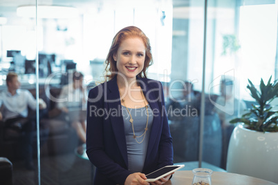 Portrait of smiling businesswoman holding digital table