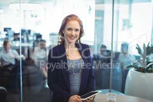 Portrait of smiling businesswoman holding digital table