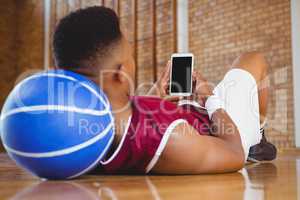 Close up of male basketball player using mobile phone