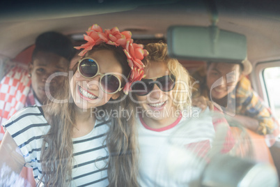 Portrait of smiling friends in camper van seen through windshield