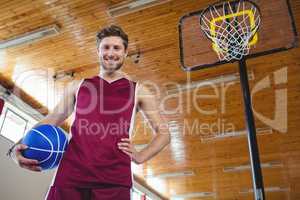 Male basketball player standing by basketball hoop