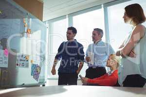 Thoughtful business colleagues looking at whiteboard in office