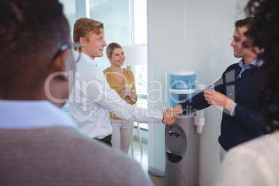 Business colleagues shaking hands at office