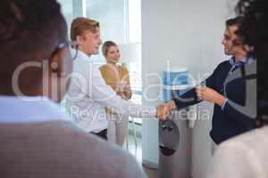 Business colleagues shaking hands at office